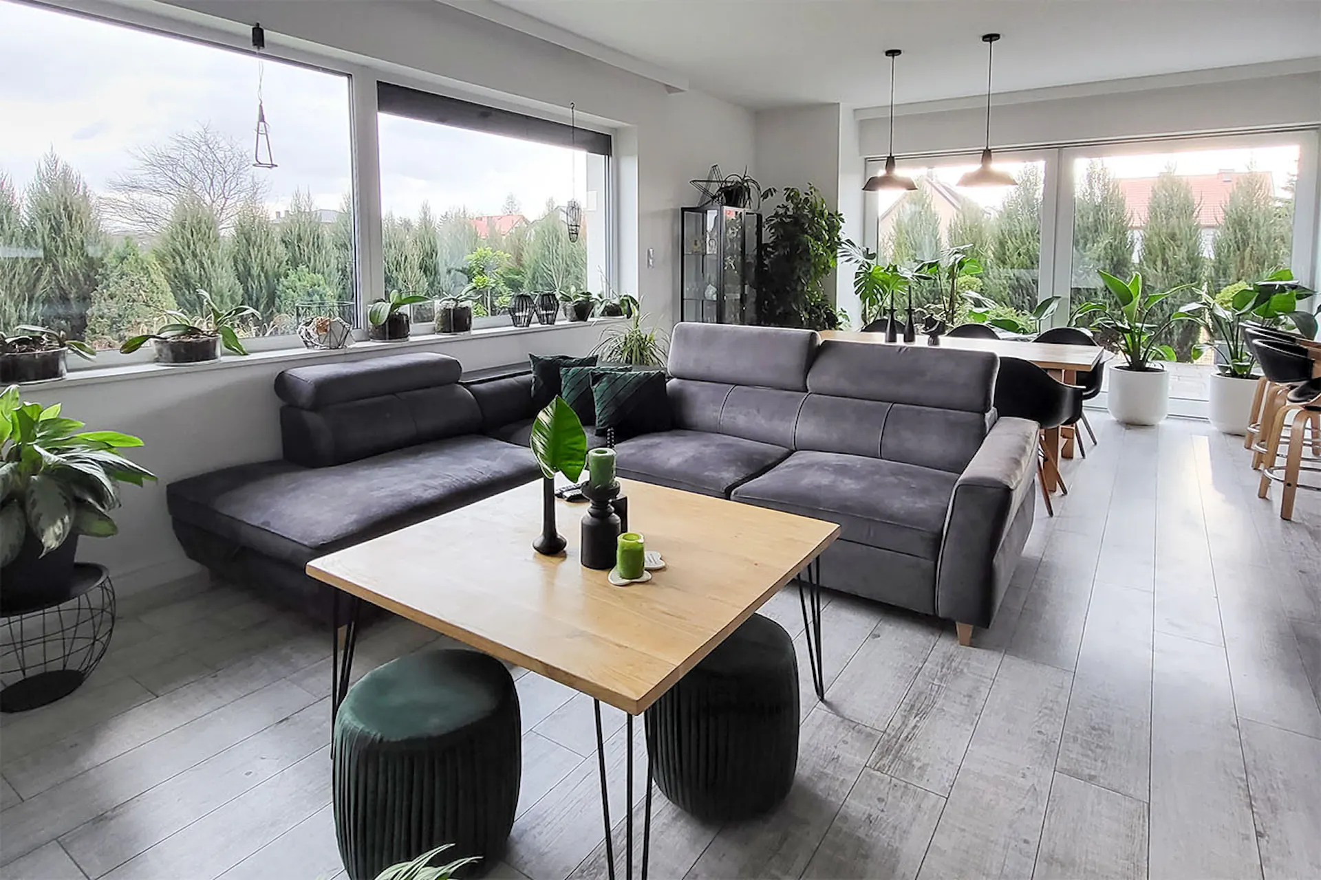 pokój dzienny z szarą sofą i kwadratowym drewnianym stolikiem kawowym w szaro-czarnej aranżacji