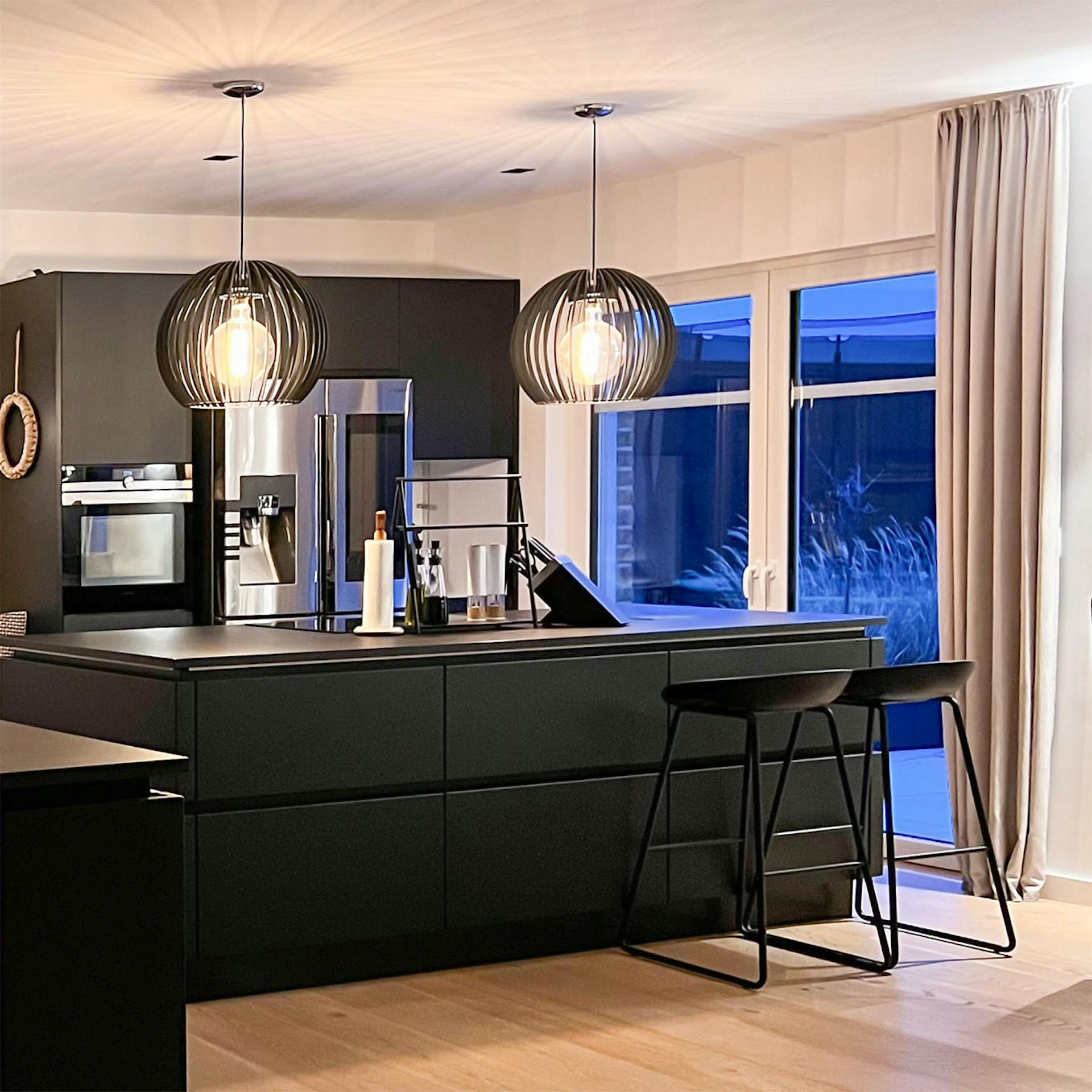 nowoczesna kuchnia z czarnymi meblami i srebrnym AGD