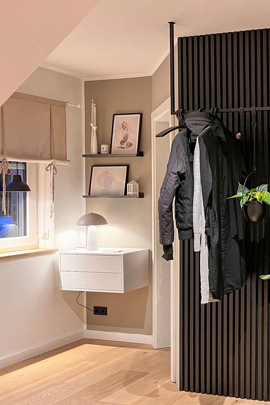 schwarze Lamellen an der Wand und ein weißer Tisch im Flur