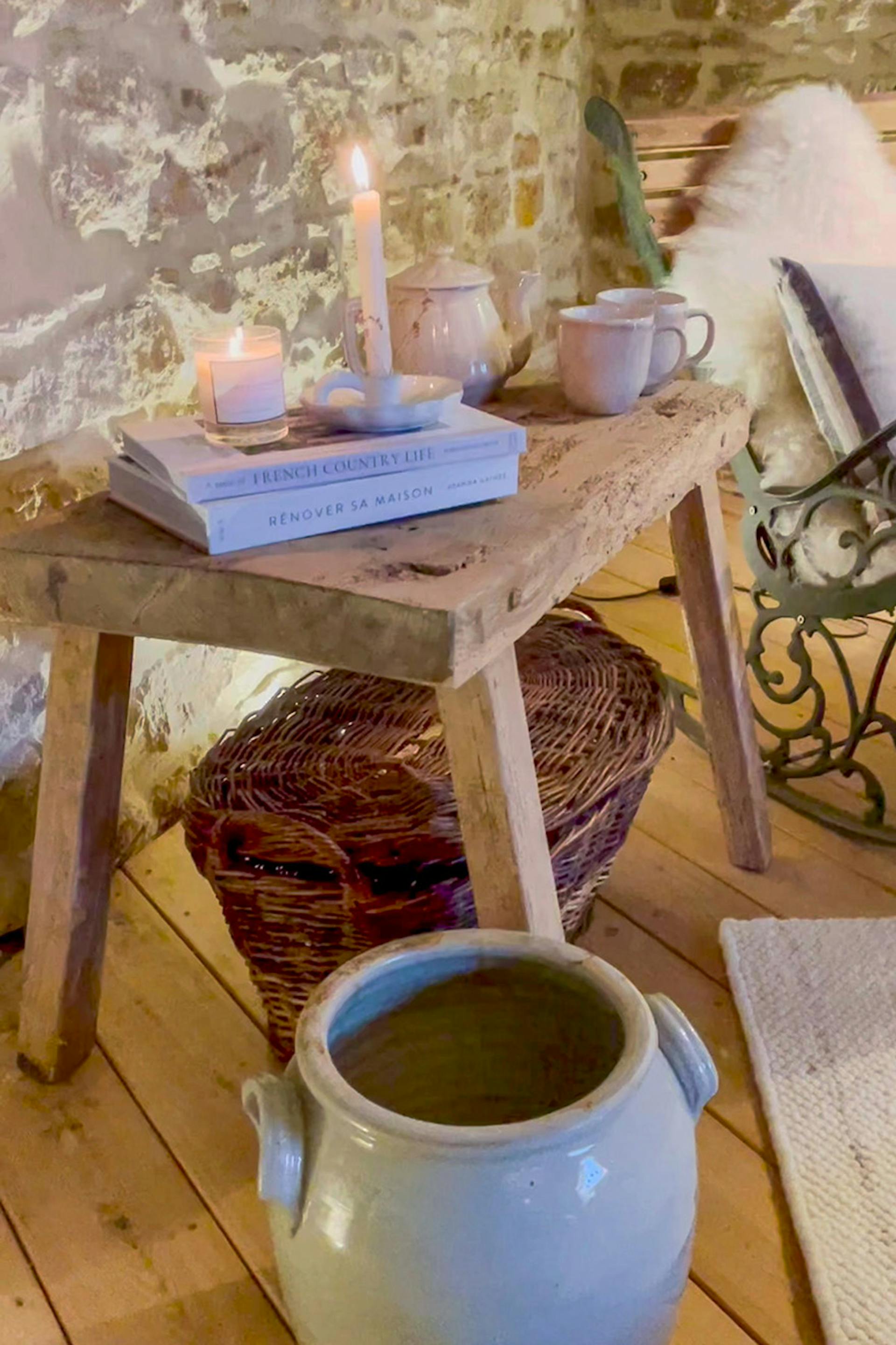 książki, świeczki i naczynia ceramiczne na drewnianym stołku