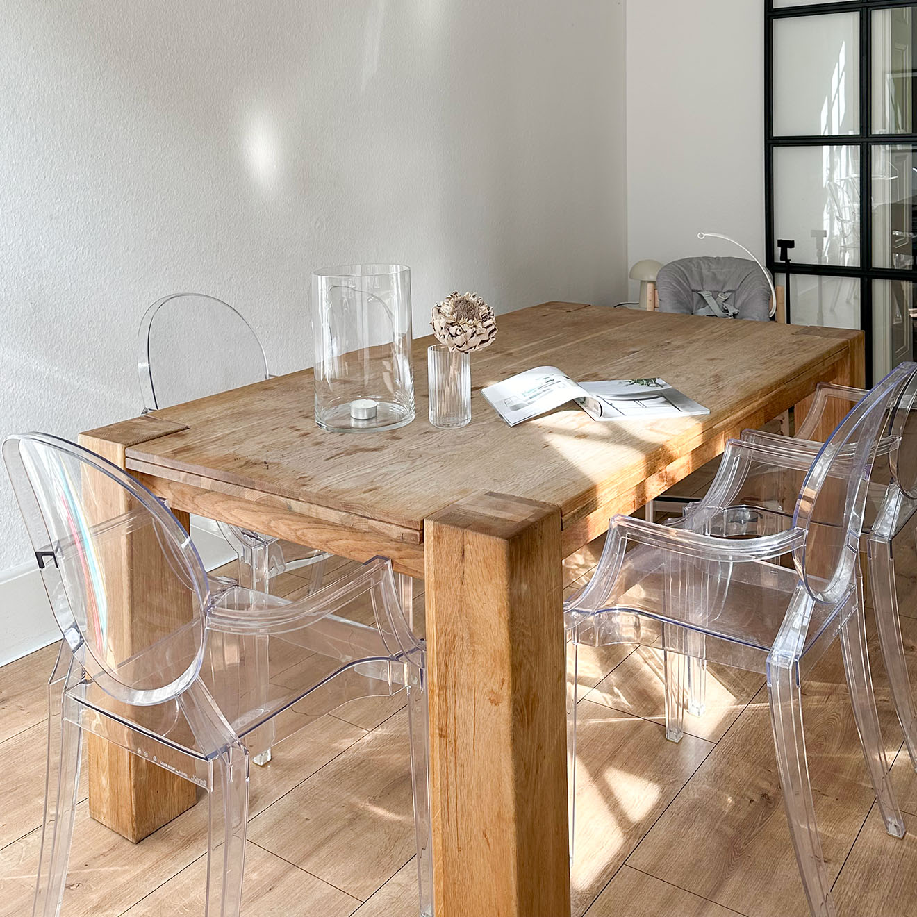 Massiver Holztisch und transparente Plastikstühle in der Küche