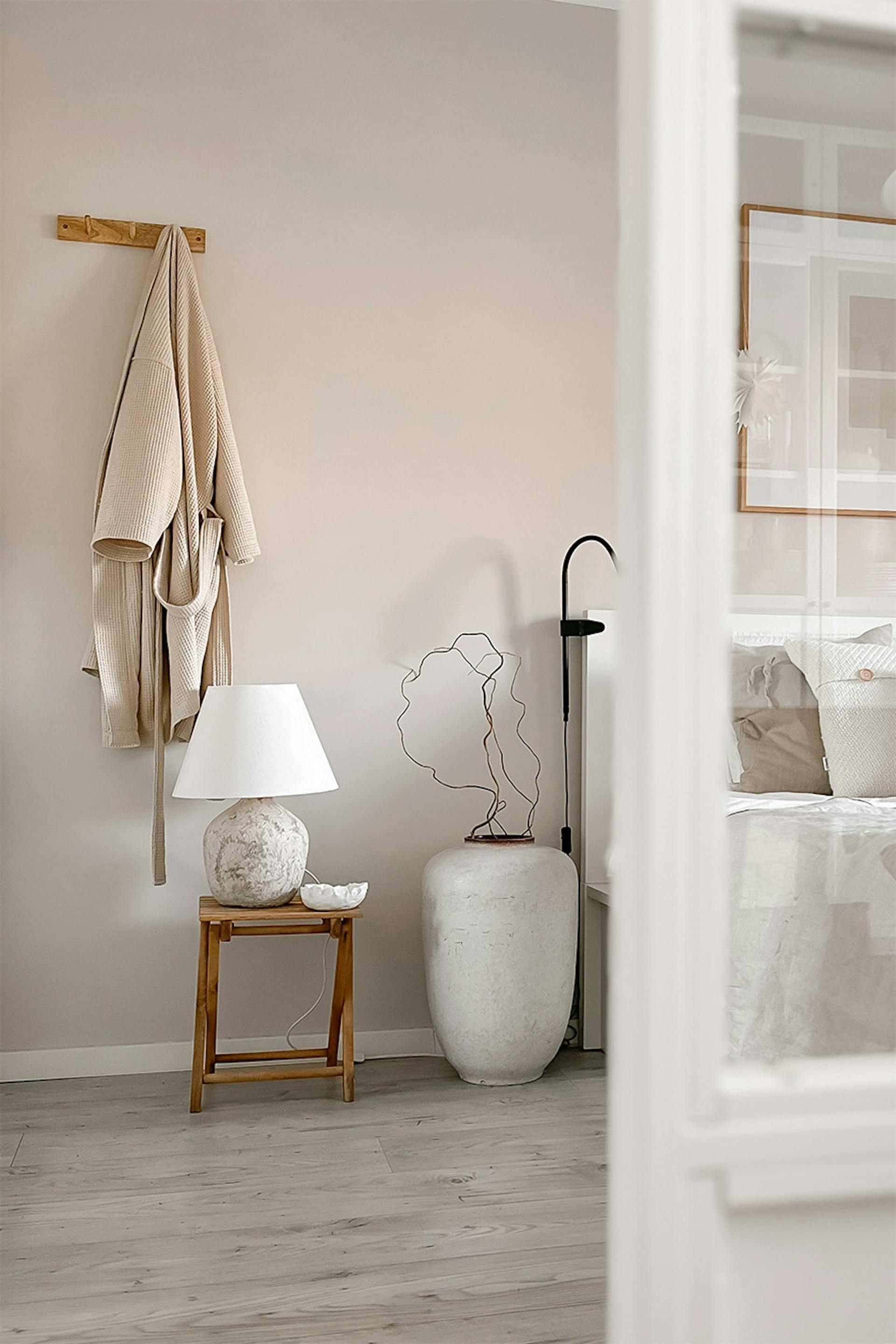 wieszak na ubrania i drewniany stolik z lampką nocną