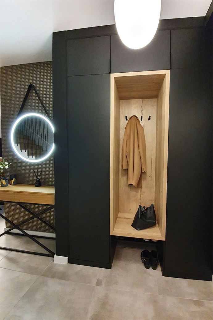czarne ściany w przedpokoju, wnęka na wieszaki, lustro z oświetleniem, loftowy stolik do przedpokoju