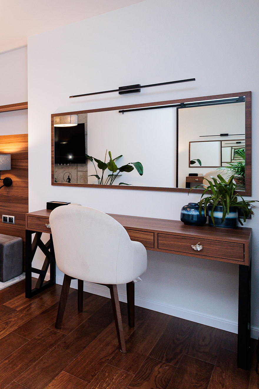 ein großer Spiegel über dem Schminktisch in einem geräumigen Schlafzimmer