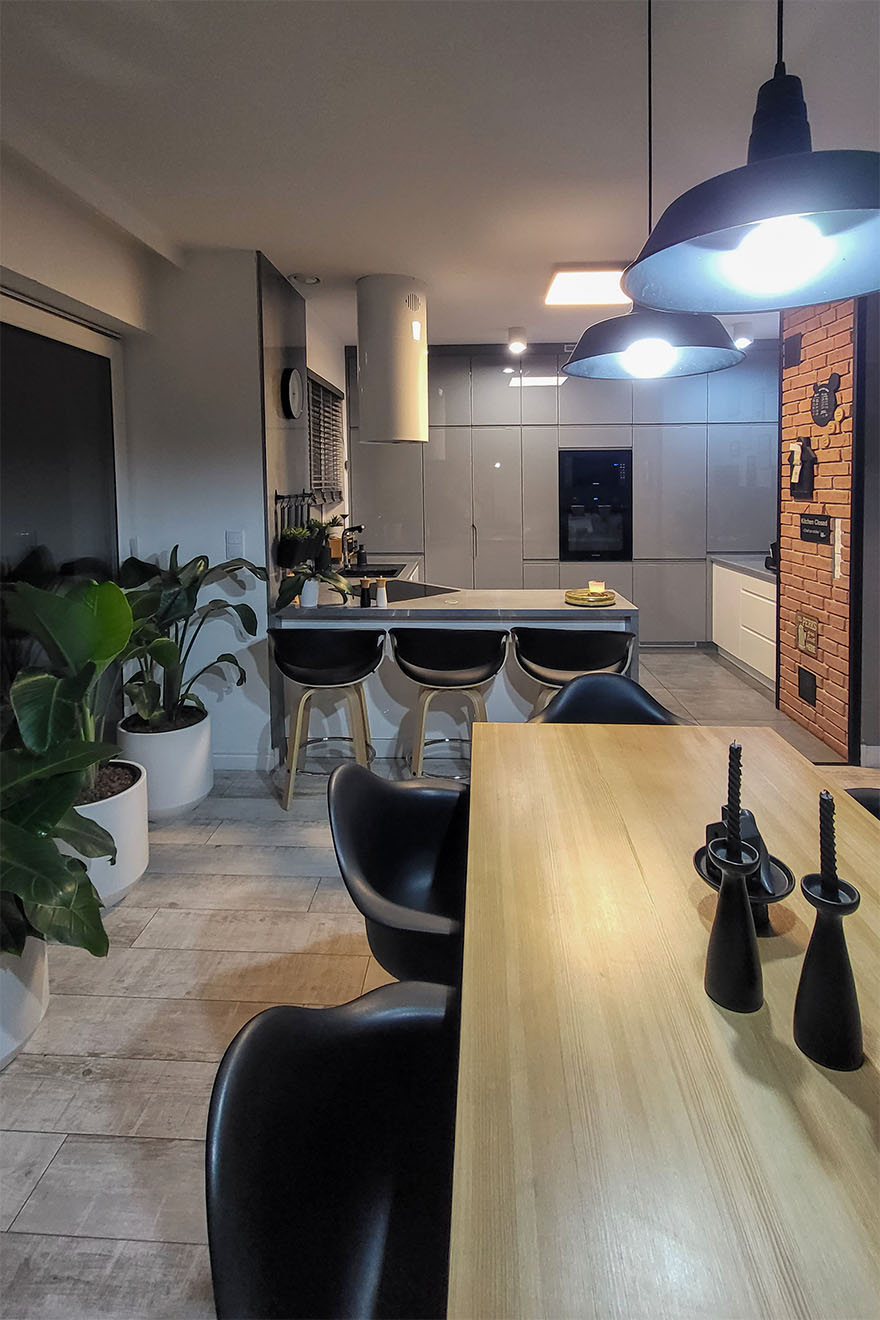 eine moderne Küche kombiniert mit einem Esszimmer, das in grauen Farben mit schwarzen Accessoires dekoriert ist