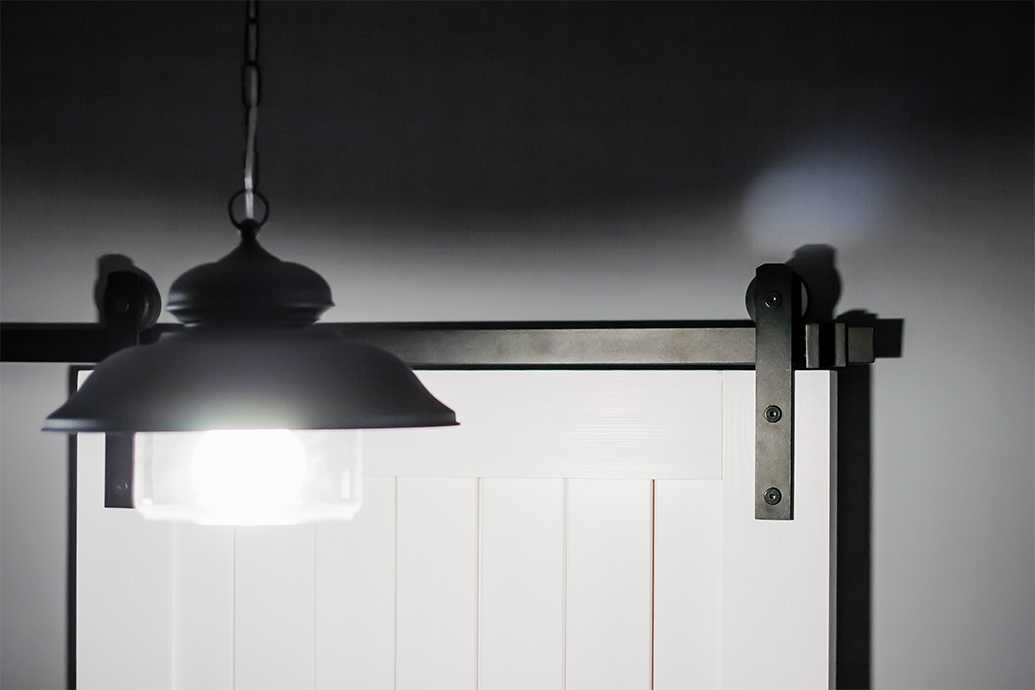 Schiebesystem, weiße Schiebetür, graue Wände in der Halle, schwarze Hängelampe in der Halle, Dekenlampe Schwarz Metall