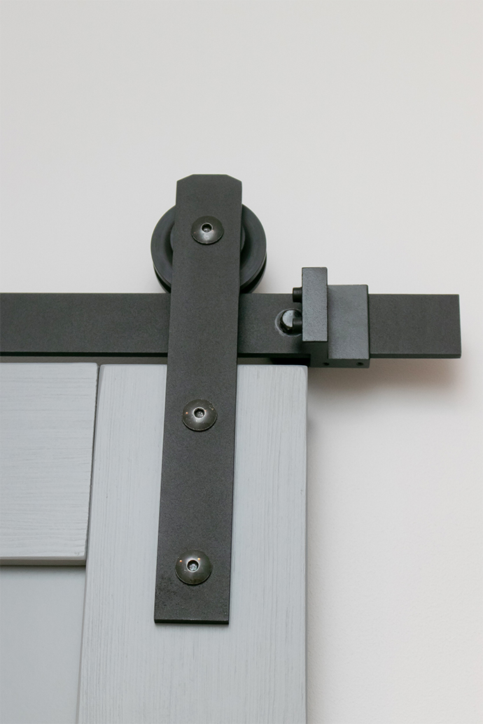 czarny system przesuwny do szarych drzwi drewnianych