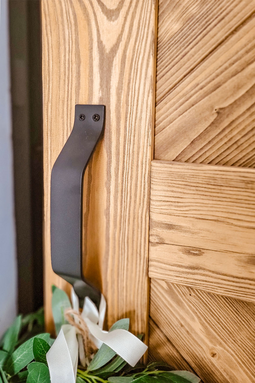 czarny uchwyt na drewnianych drzwiach