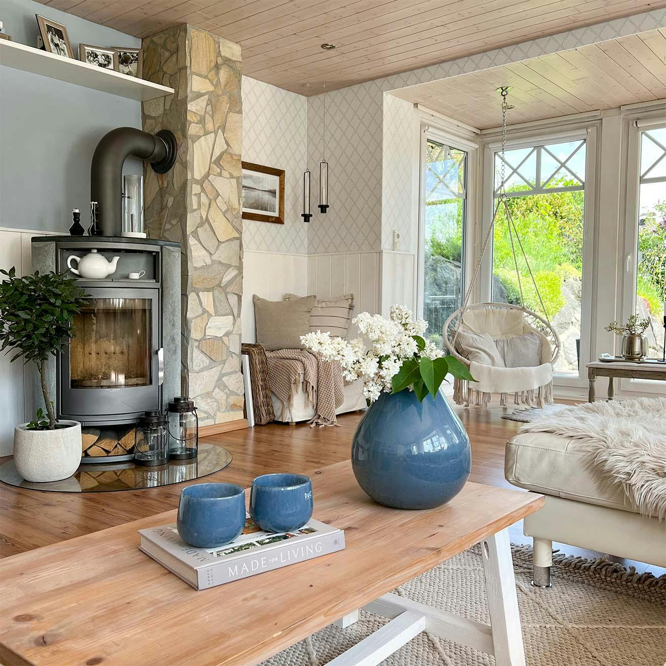 kominek w przestronnym salonie z dużymi oknami