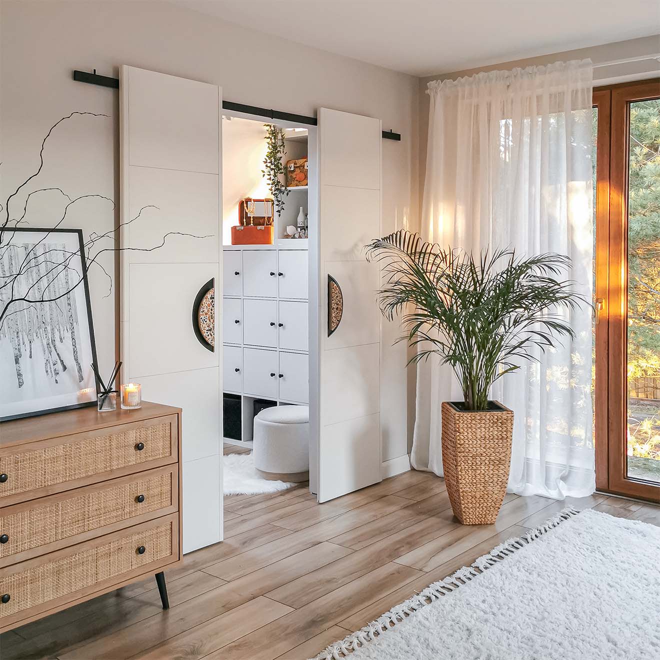 sypialnia z garderobą za białymi podwójnymi drzwiami przesuwnymi