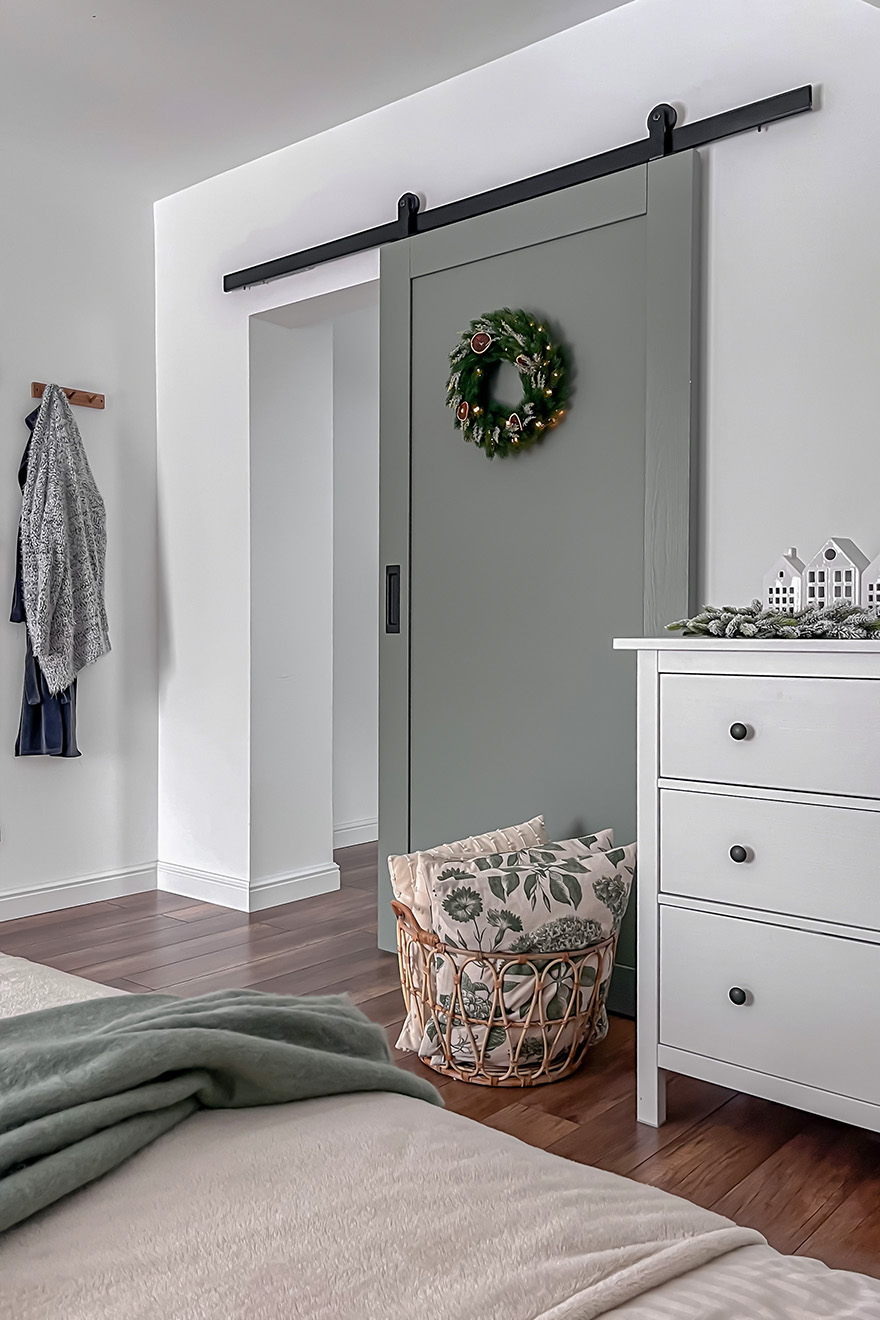 biała komoda i szare drzwi przesuwne w sypialni