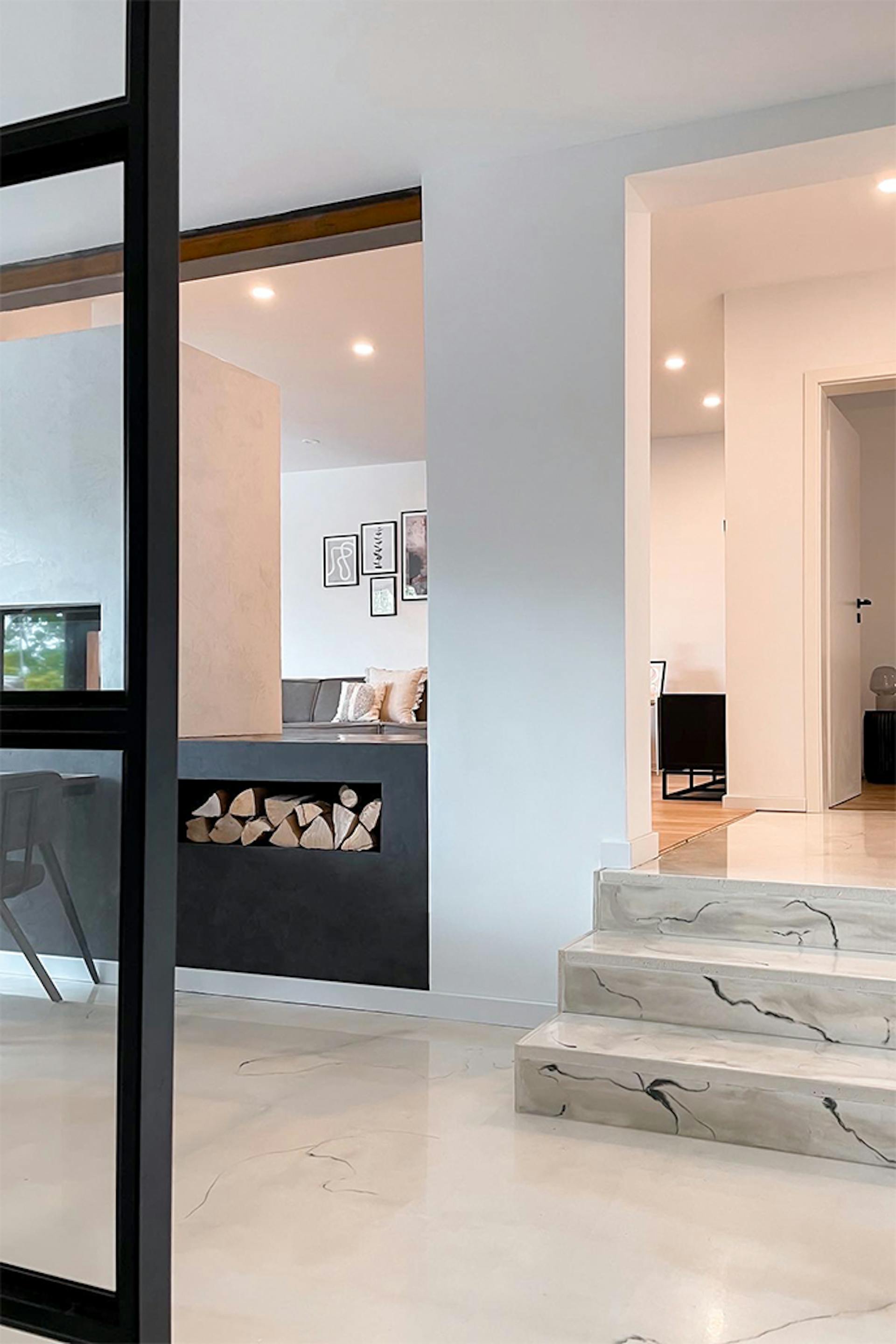 nowoczesne wnętrze z białymi ścianami, jasną podłogą i czarnymi dodatkami