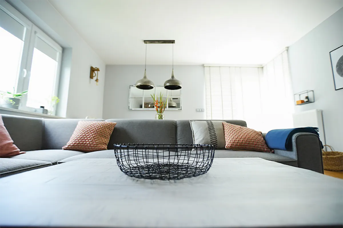 szara sofa w salonie, wiszące lampy metalowe,