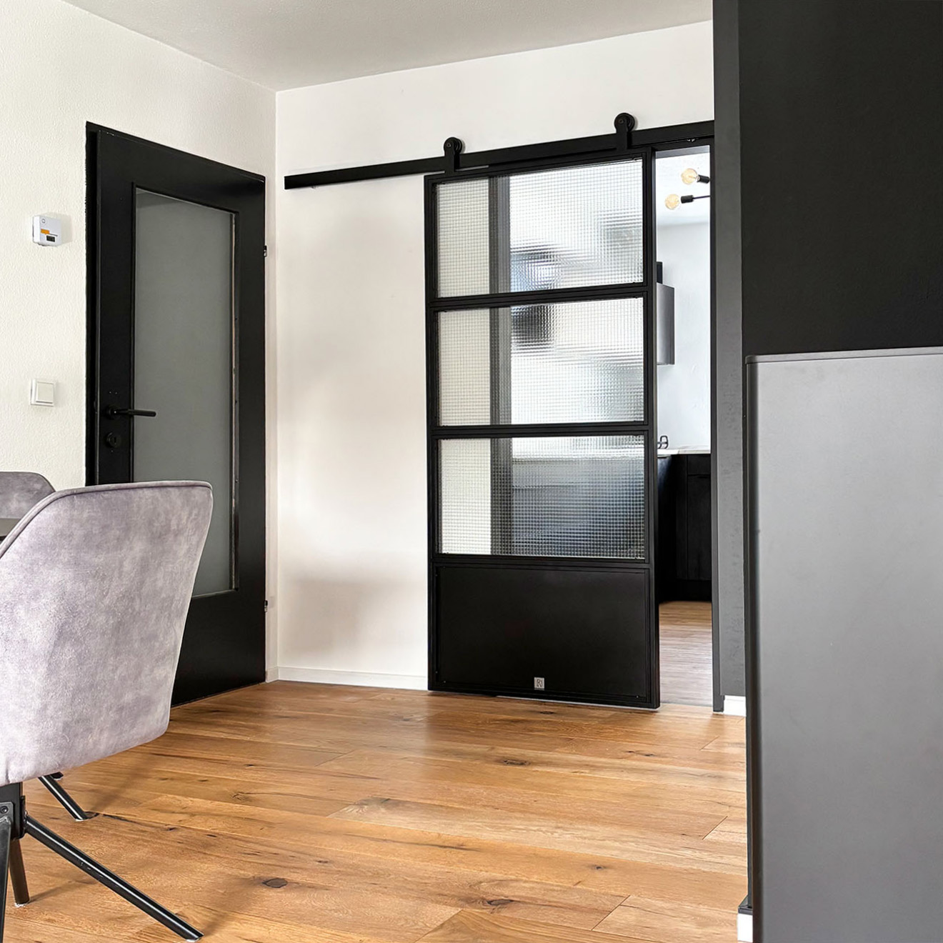 drzwi przesuwne ze szkłem zbrojonym w minimalistycznym mieszkaniu