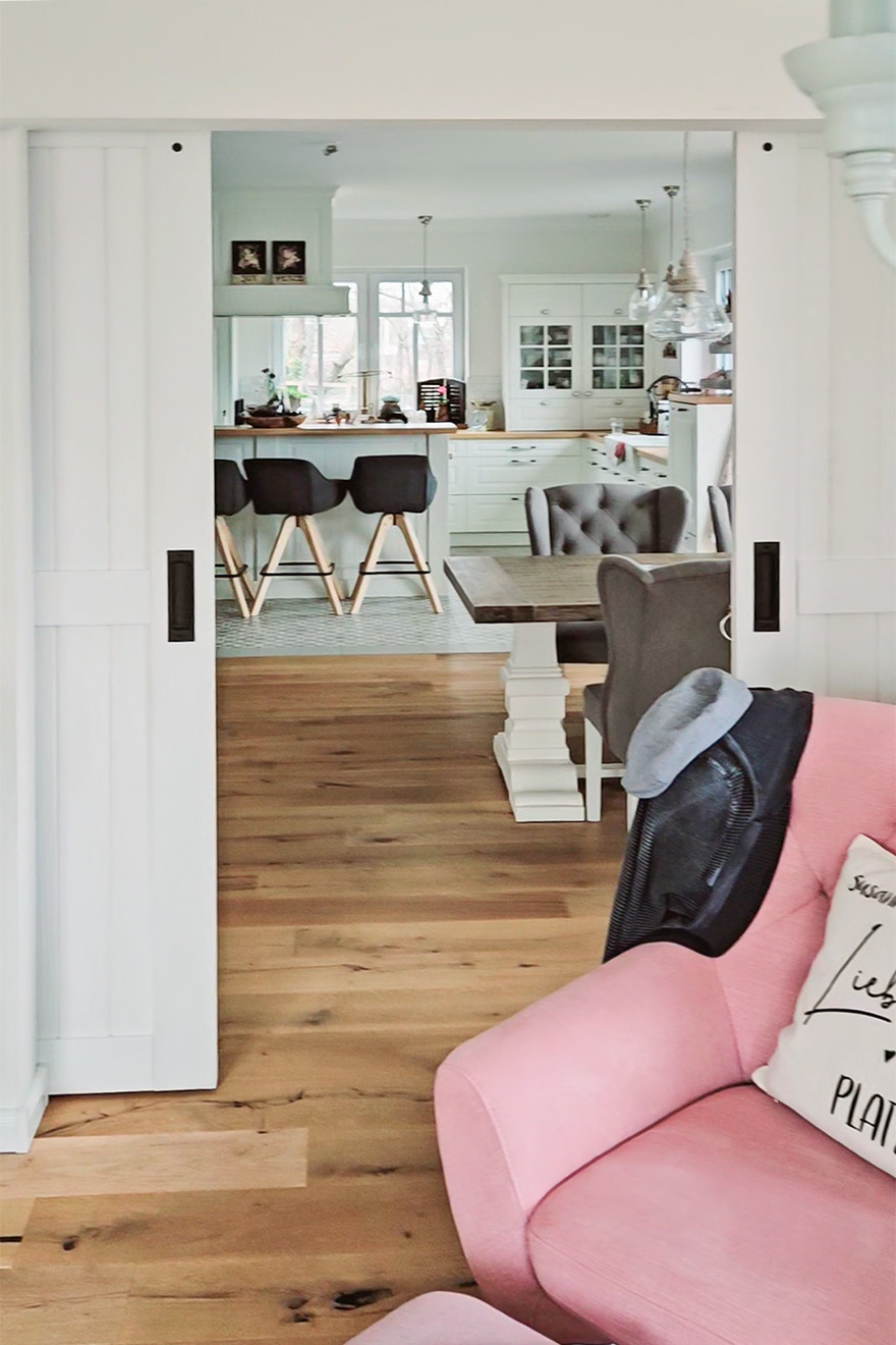 otwarte drzwi przesuwne ukazujące fragment jadalni i kuchni w stylu rustykalnym nowoczesnym