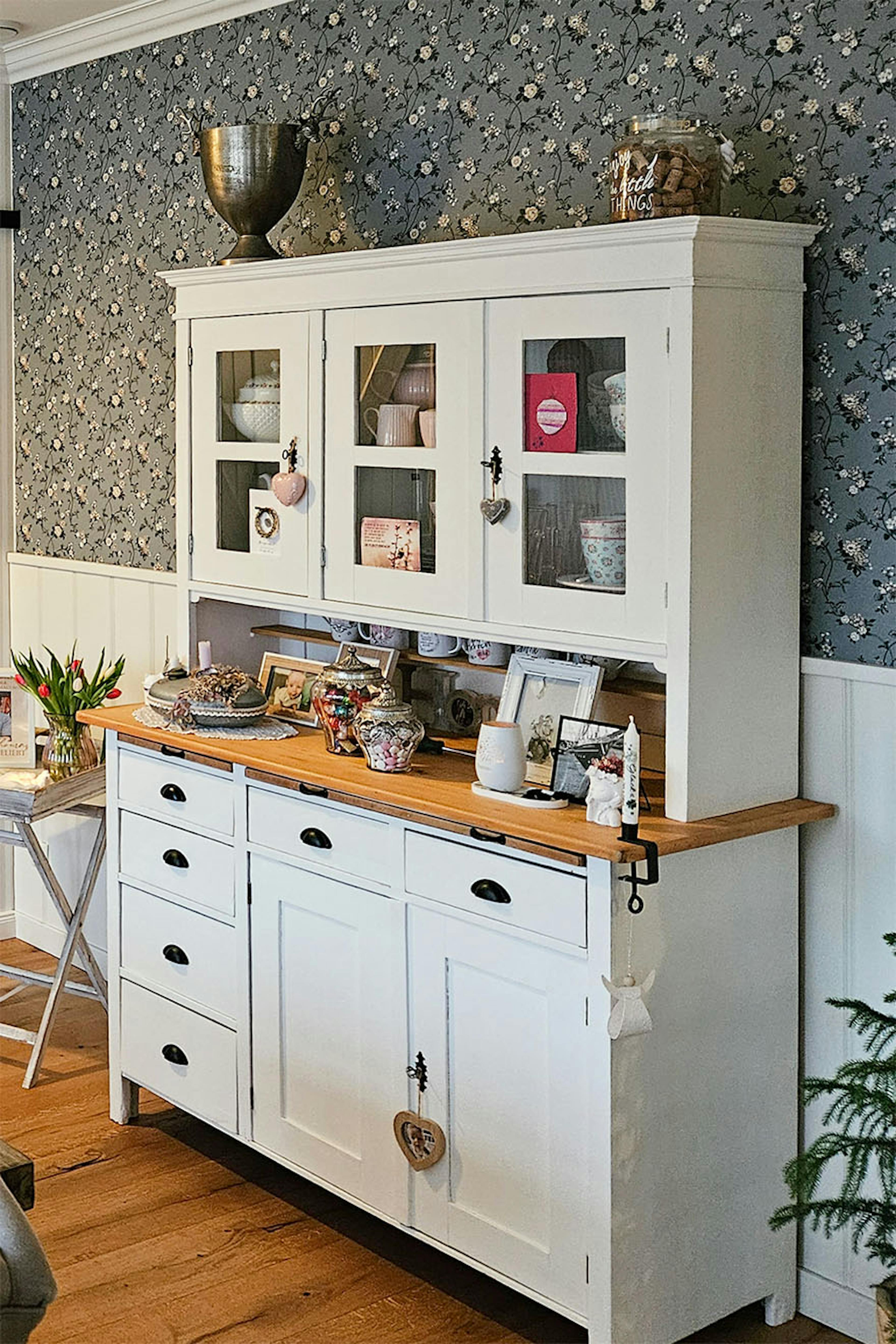 Weißes Sideboard mit Glas zur Präsentation von Geschirr und Dekorationen