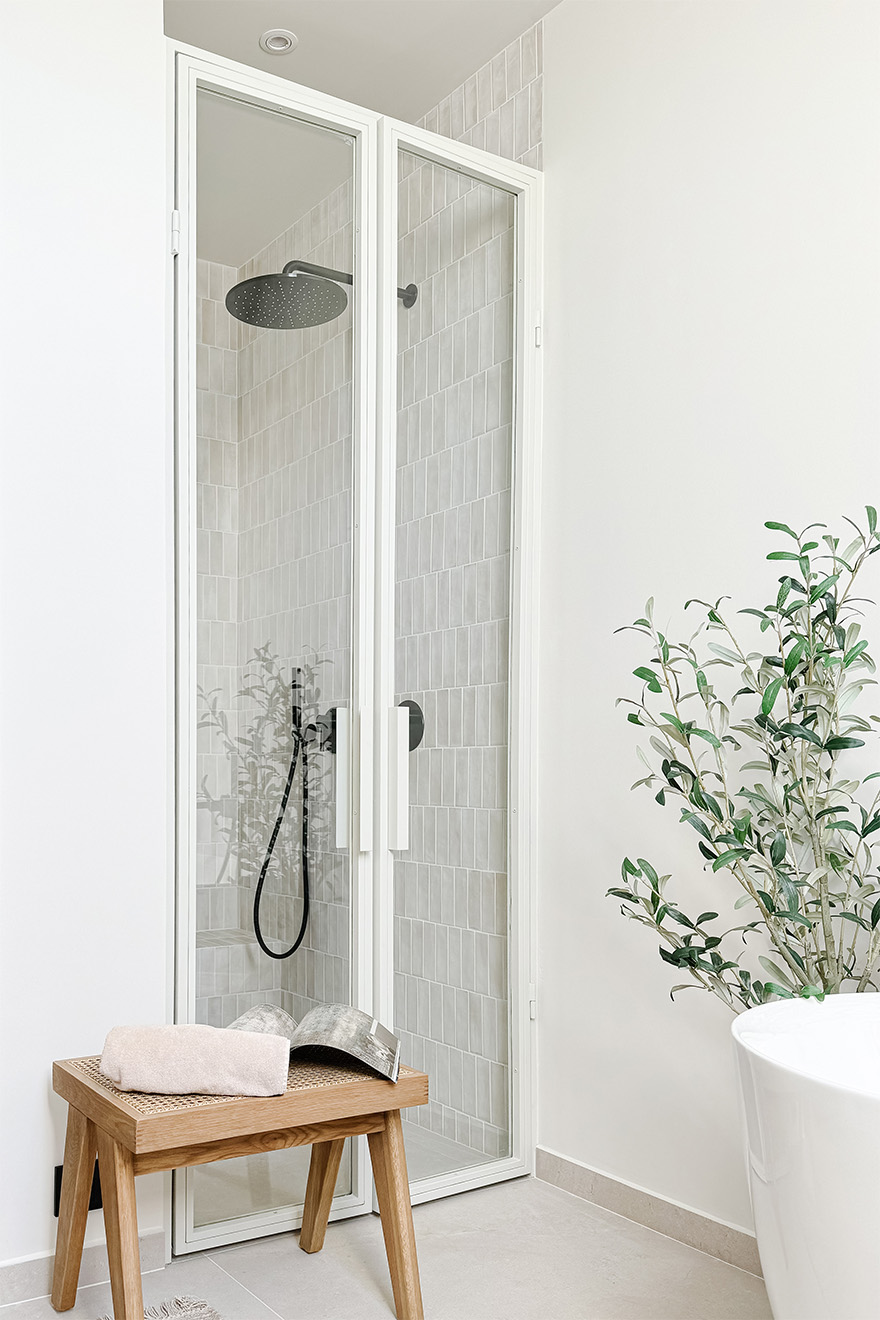 Weiße Glastür zur Duschkabine in der Nische