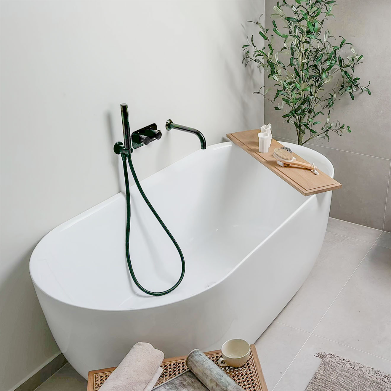 Weiße ovale Badewanne mit schwarzen Armaturen in einem minimalistischen Badezimmer