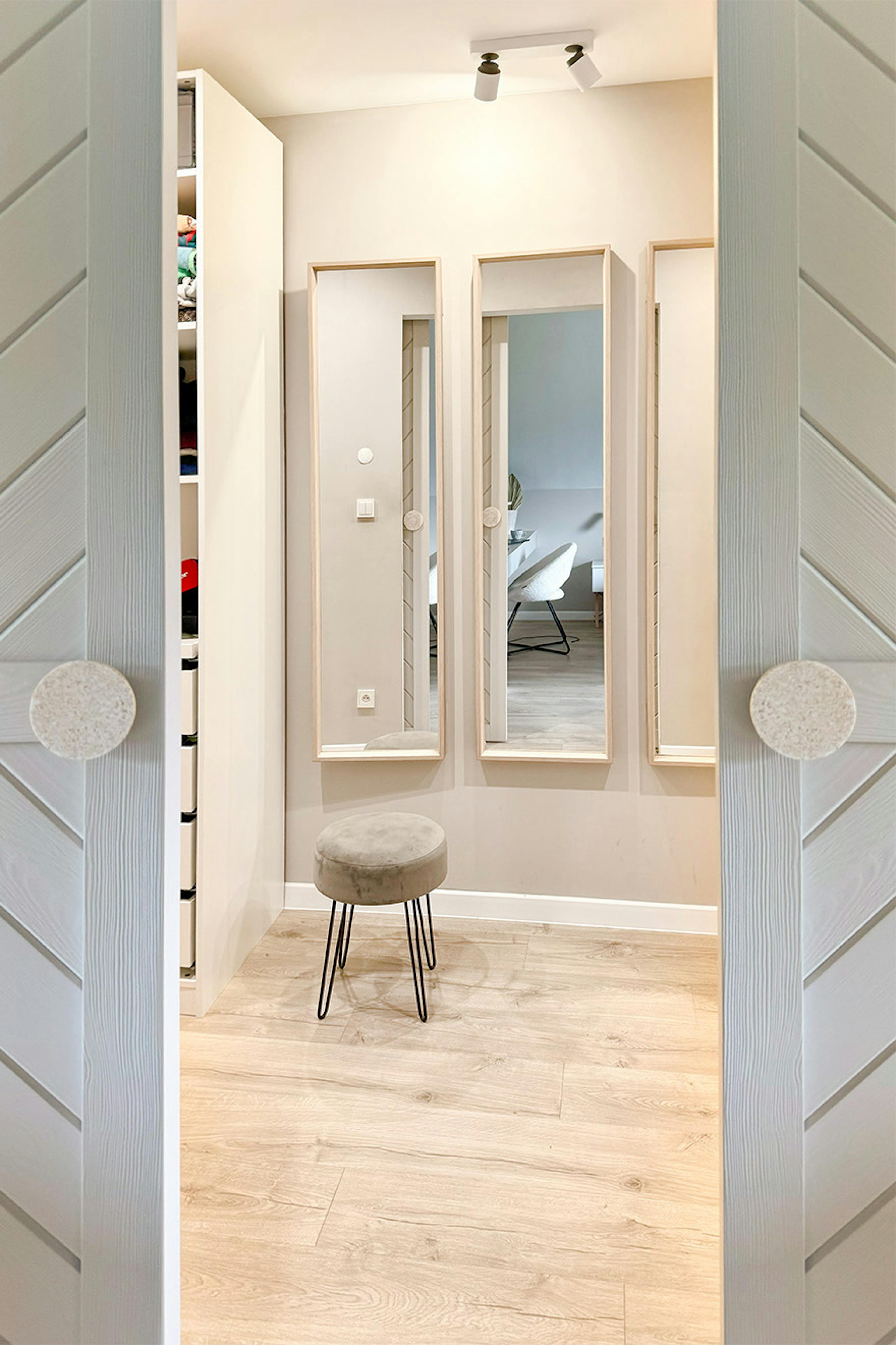 ein Satz von drei langen Spiegeln an der Wand im Ankleidezimmer