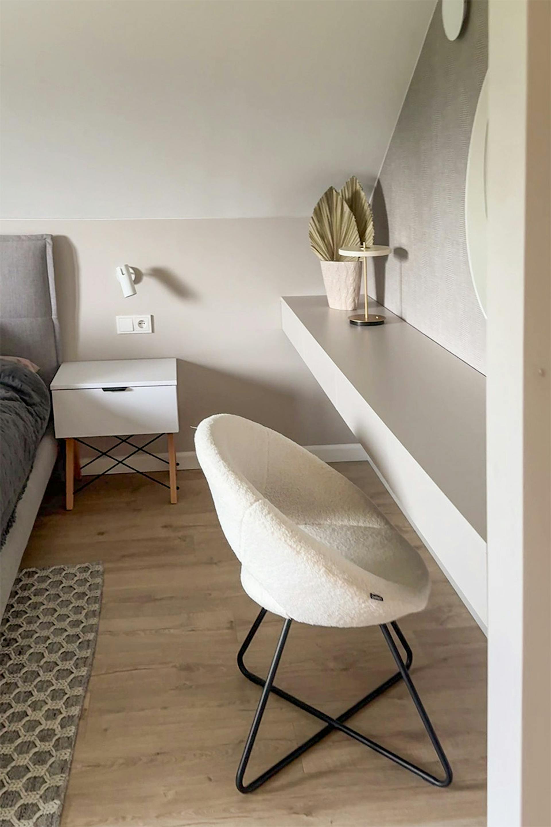 Cremefarbener Polsterstuhl neben dem Schminktisch in einem minimalistischen Schlafzimmer