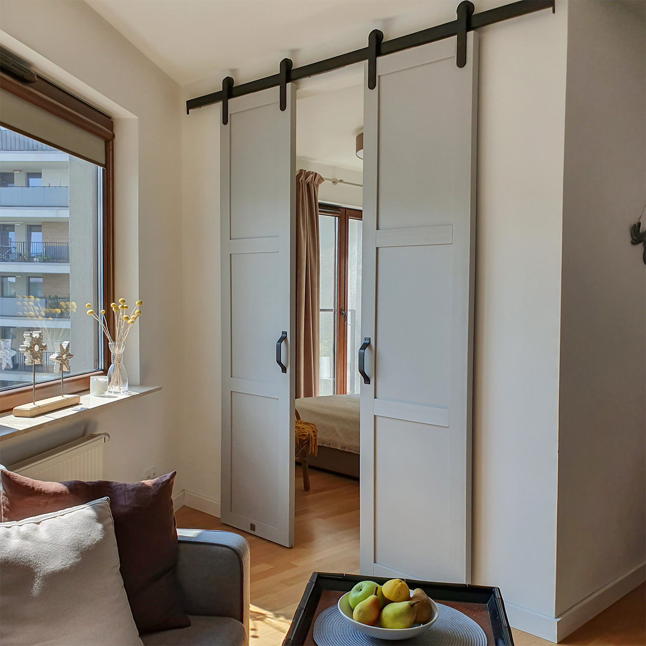 szare, dwuskrzydłowe drzwi przesuwne do sypialni w małym mieszkaniu