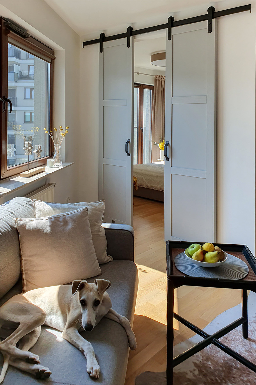 Sofa und Couchtisch vor den Schiebetüren, die vom Wohnzimmer zum Schlafzimmer führen