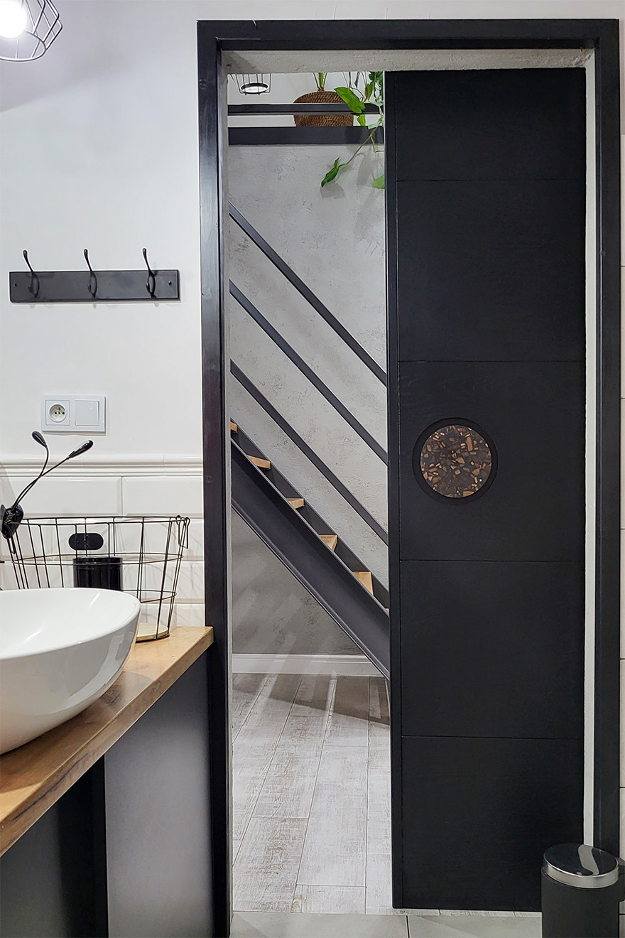 czarne drzwi oddzielające łazienkę od przedpokoju