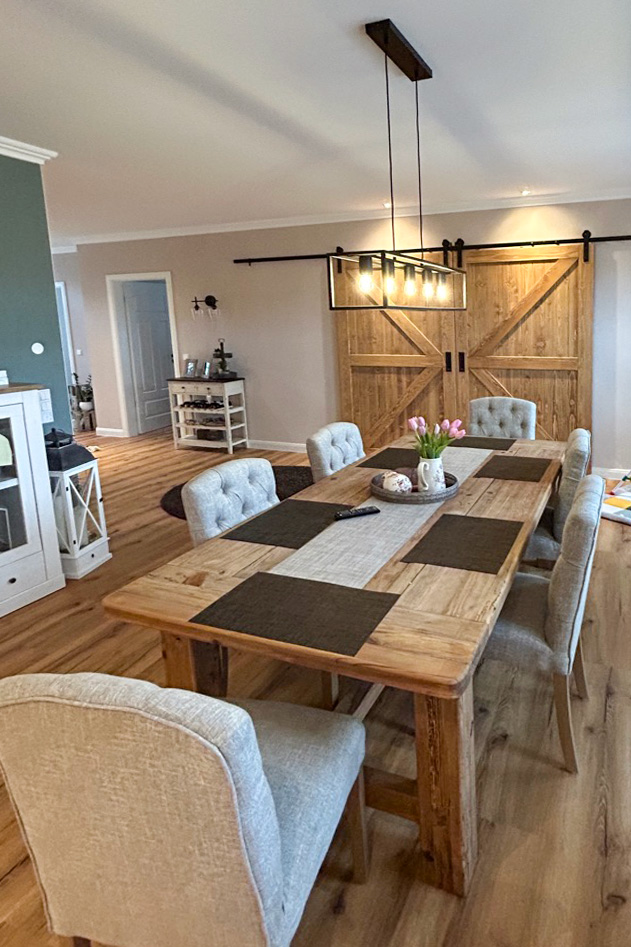 Ein großer Holztisch in einem Esszimmer, das in Beige- und Brauntönen dekoriert ist