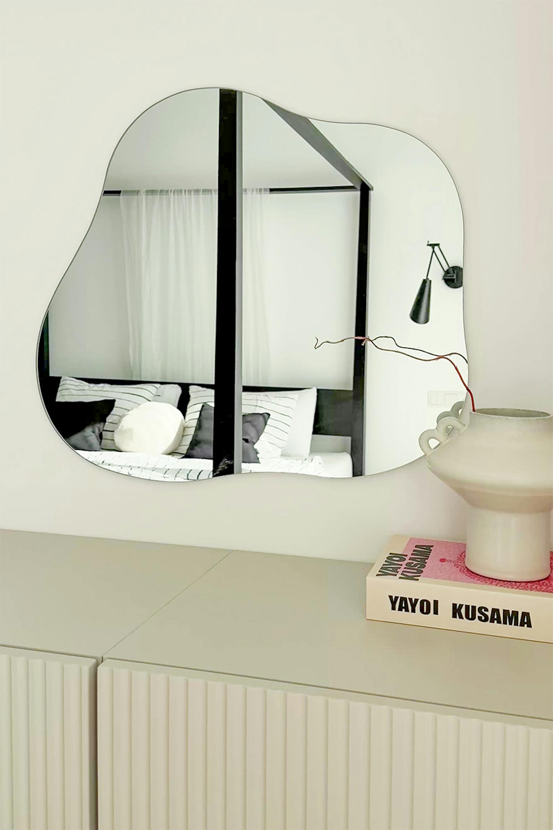 ein moderner Wandspiegel mit unregelmäßiger, organischer Form in einem minimalistischen Interieur