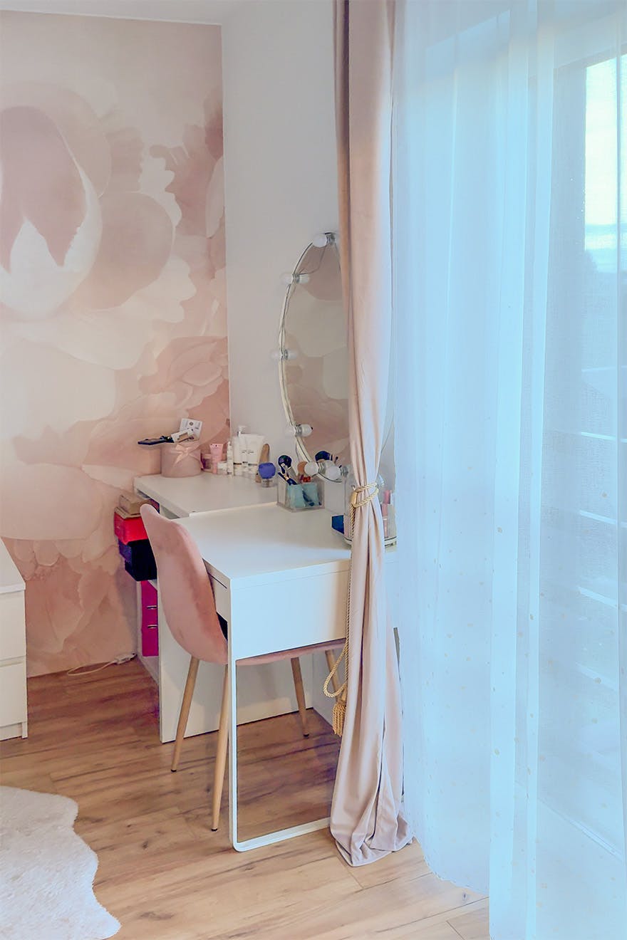 Białe biurko/toaletka i różowe welurowe krzesło; Okrągłe lustro oświetlone w stylu Hollywood.