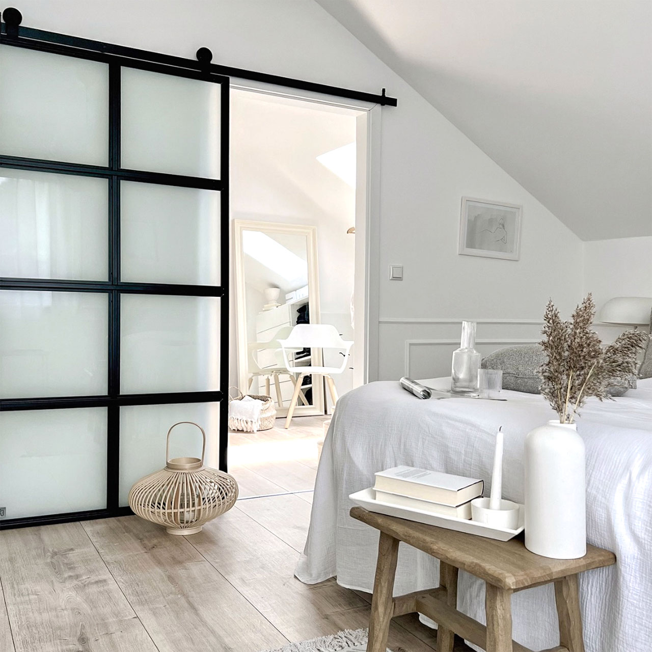 sypialnia na poddaszu z garderobą i drzwiami przesuwnymi urządzona w stylu nordyckim