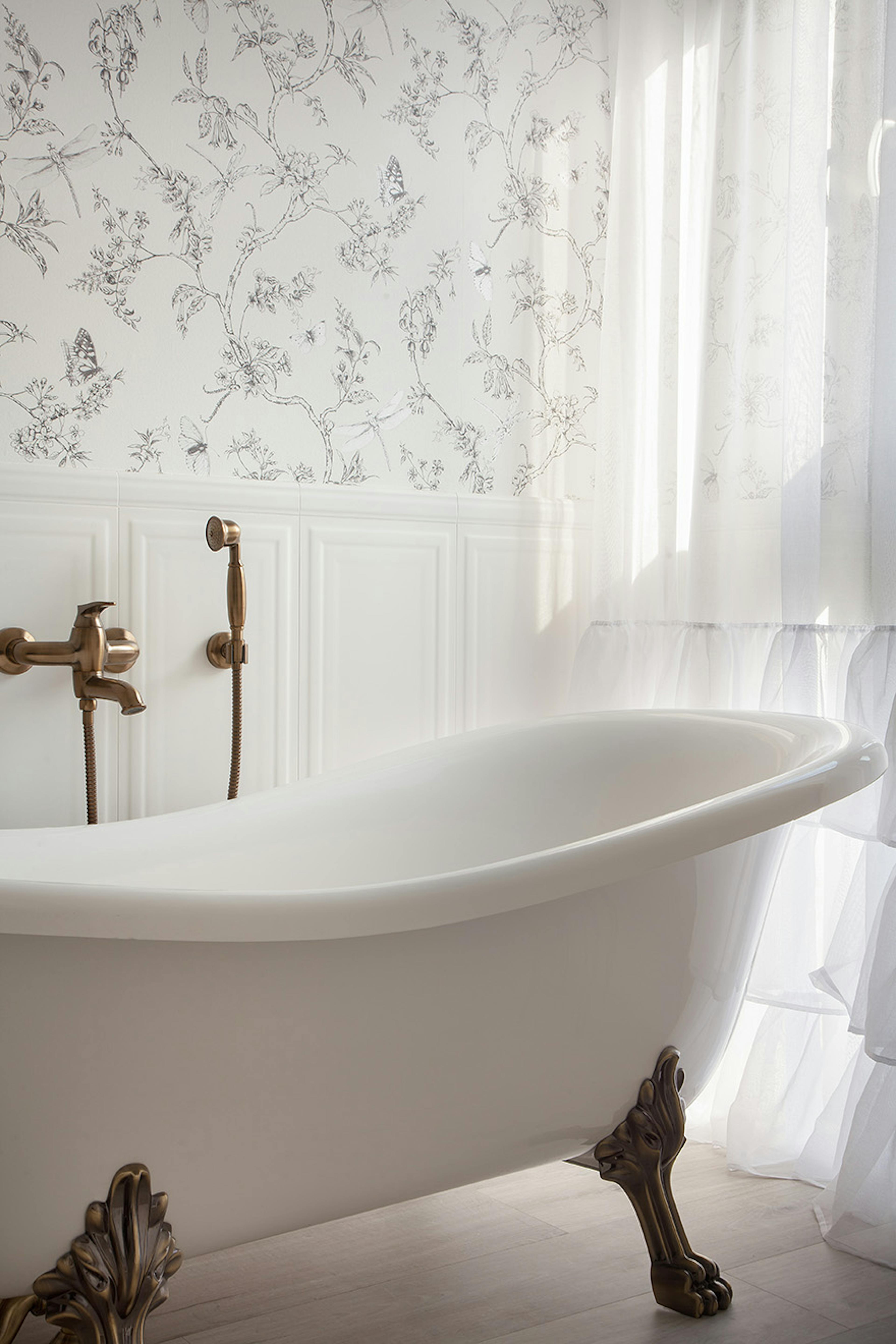 freistehende Badewanne auf dekorativen Beinen in einem Badezimmer im provenzalischen Stil