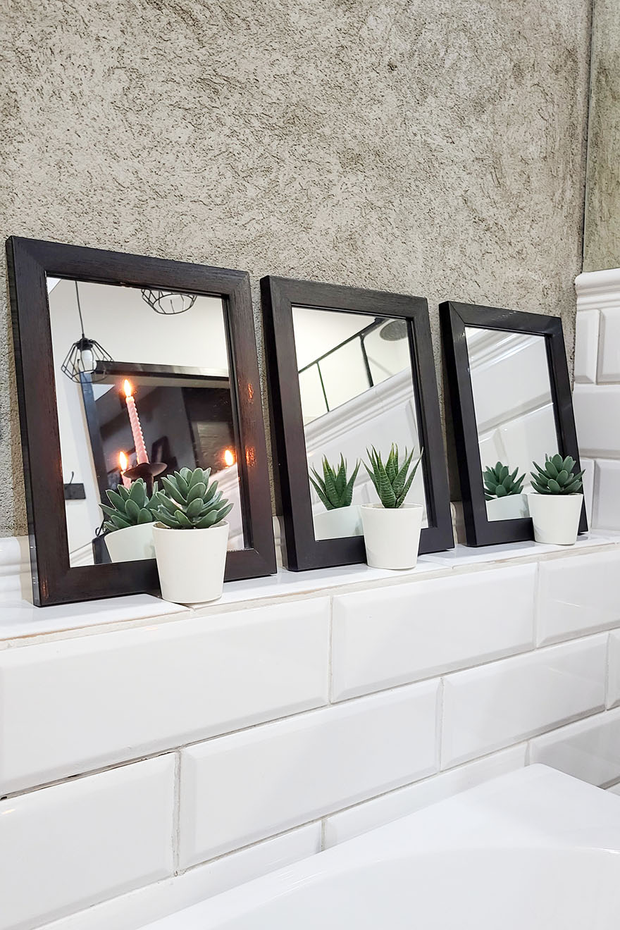 zestaw małych kwadratowych luster w ramkach nad wanną w łazience