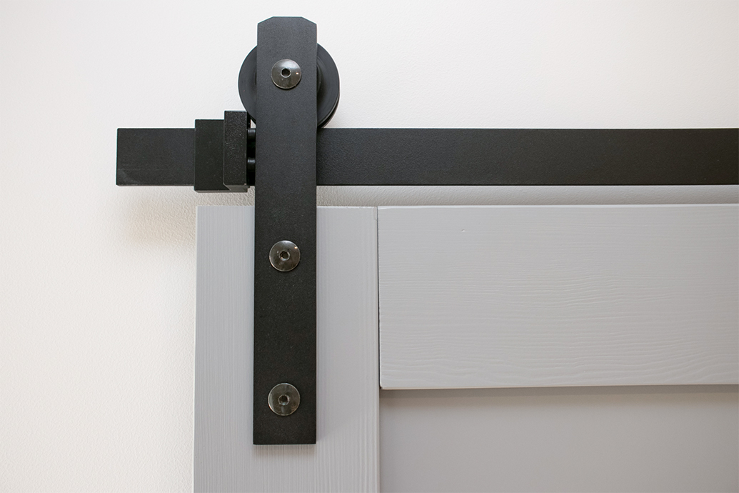 czarny system przesuwny do szarych drzwi drewnianych