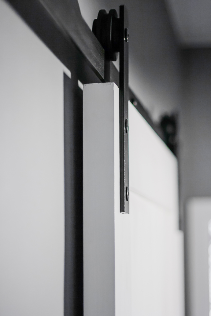 Schiebesystem, weiße Schiebetür, graue Wände in der Halle