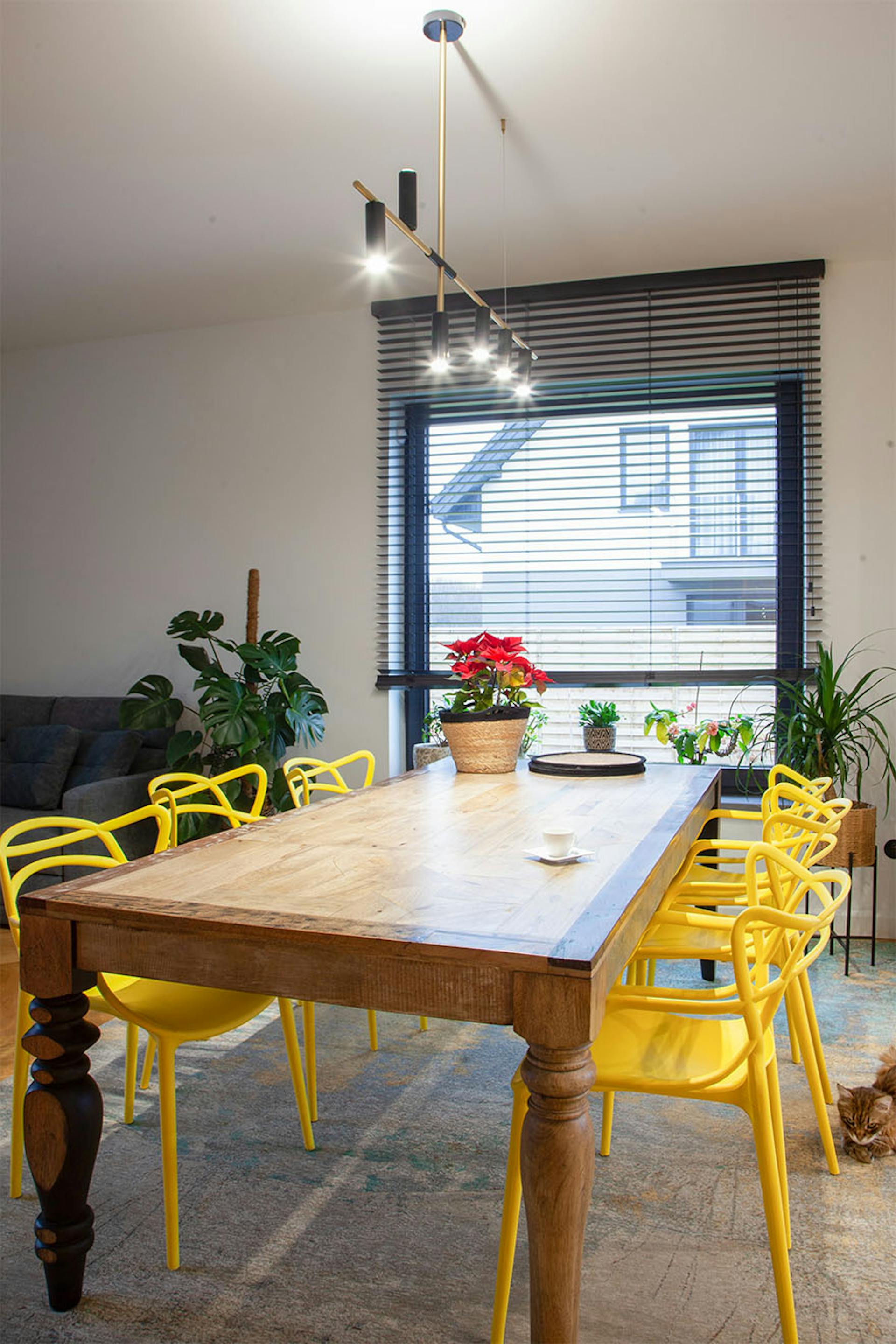 großer Holztisch und gelbe Stühle in einem modernen Speisesaal