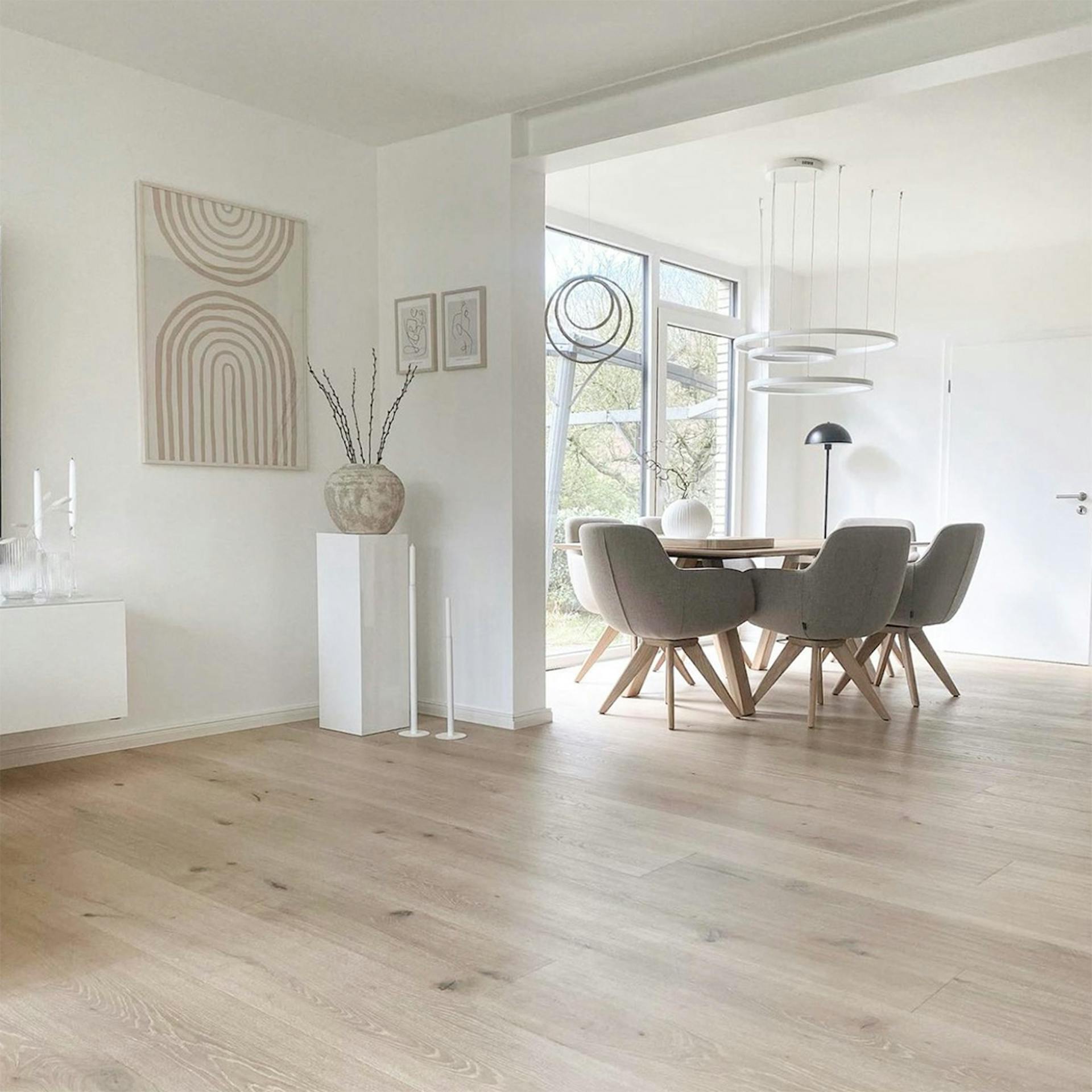 przestronny salon połączony z jadalnią w jasno beżowo brązowej aranżacji w stylu nordyckim