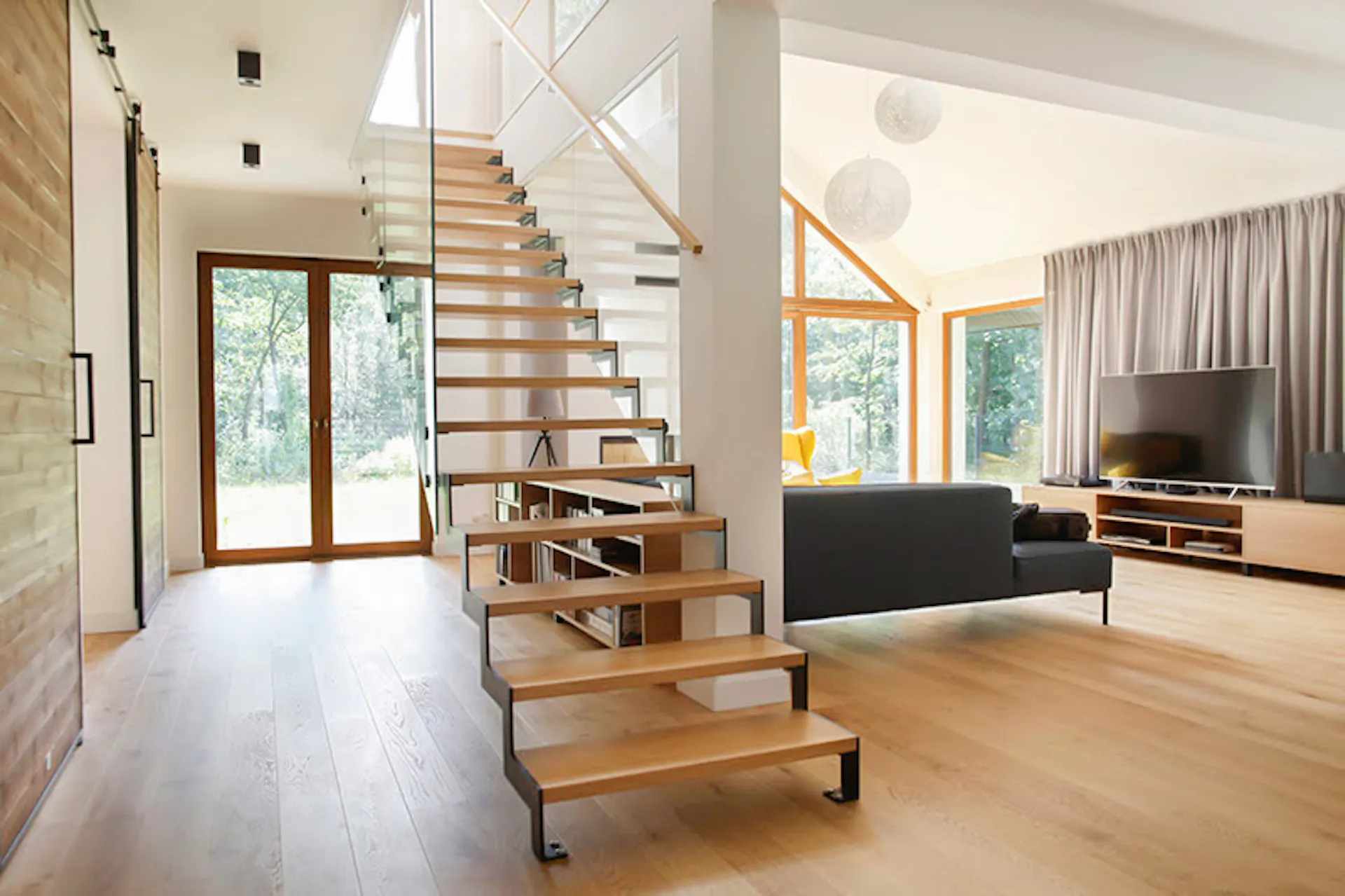 durchbrochene Holztreppe im geräumigen Wohnzimmer