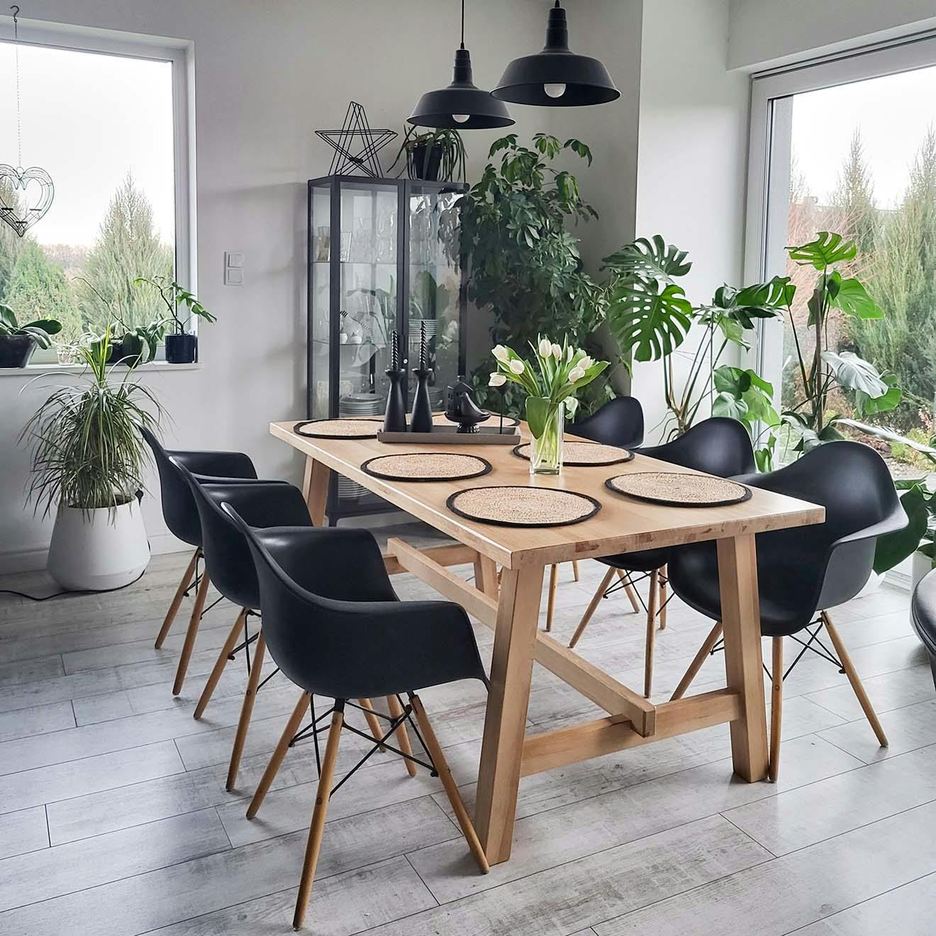 großer Esstisch aus Holz mit schwarzen Stühlen im Essbereich eines modernen Wohnzimmers