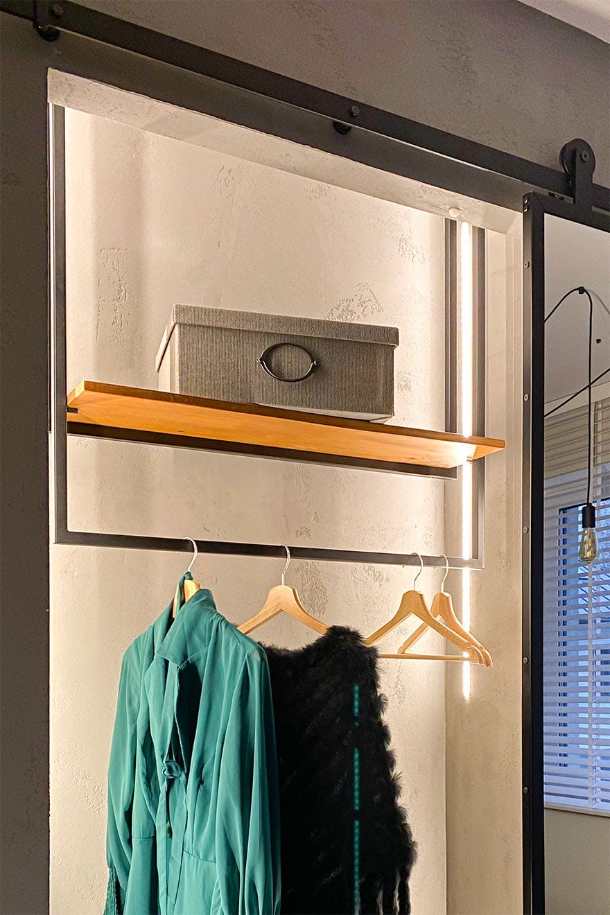 ein kleines Ankleidezimmer in einer Nische in einem Schlafzimmer im Loft-Stil