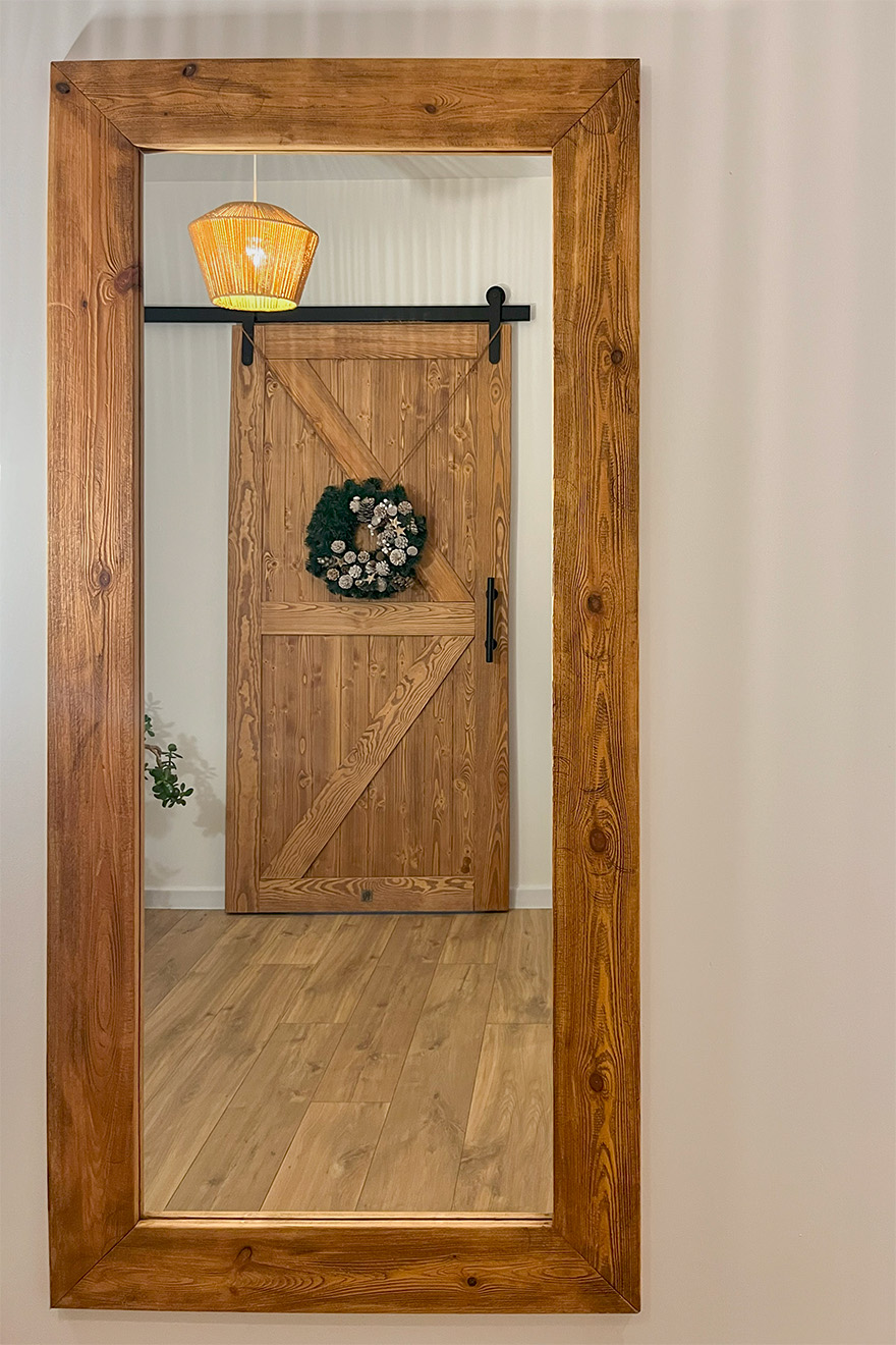 drewniane drzwi przesuwne i duże lustro ścienne w drewnianej ramie