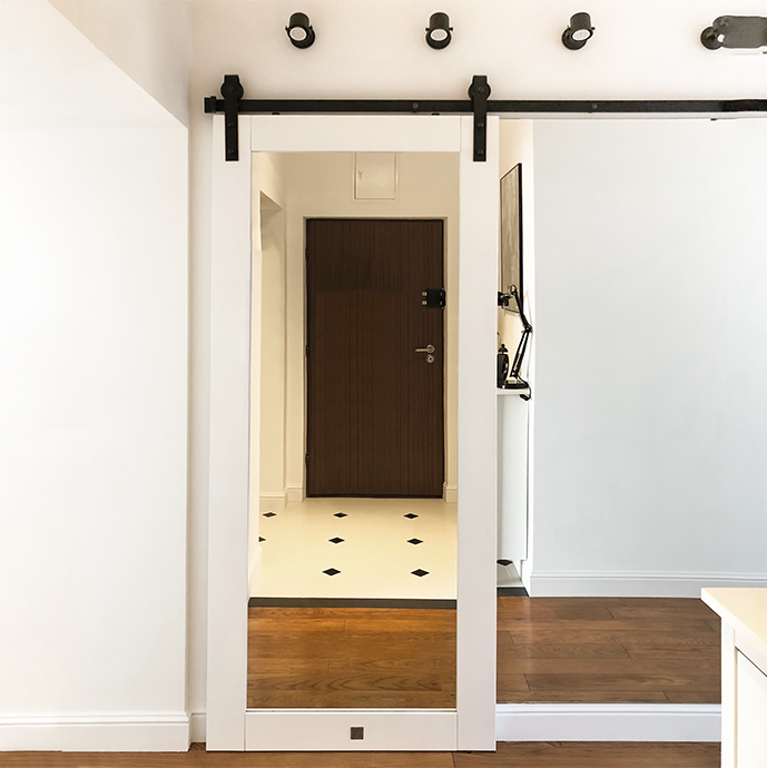 białe drewniane drzwi przesuwne z dużym lustrem w przedpokoju