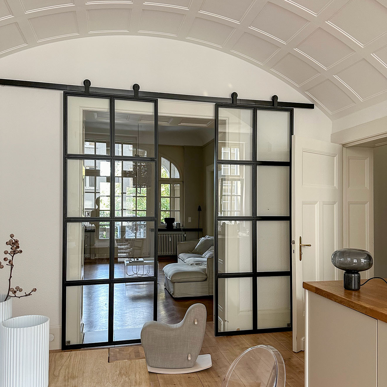 szklane, dwuskrzydłowe drzwi przesuwne prowadzące do salonu w starej kamienicy