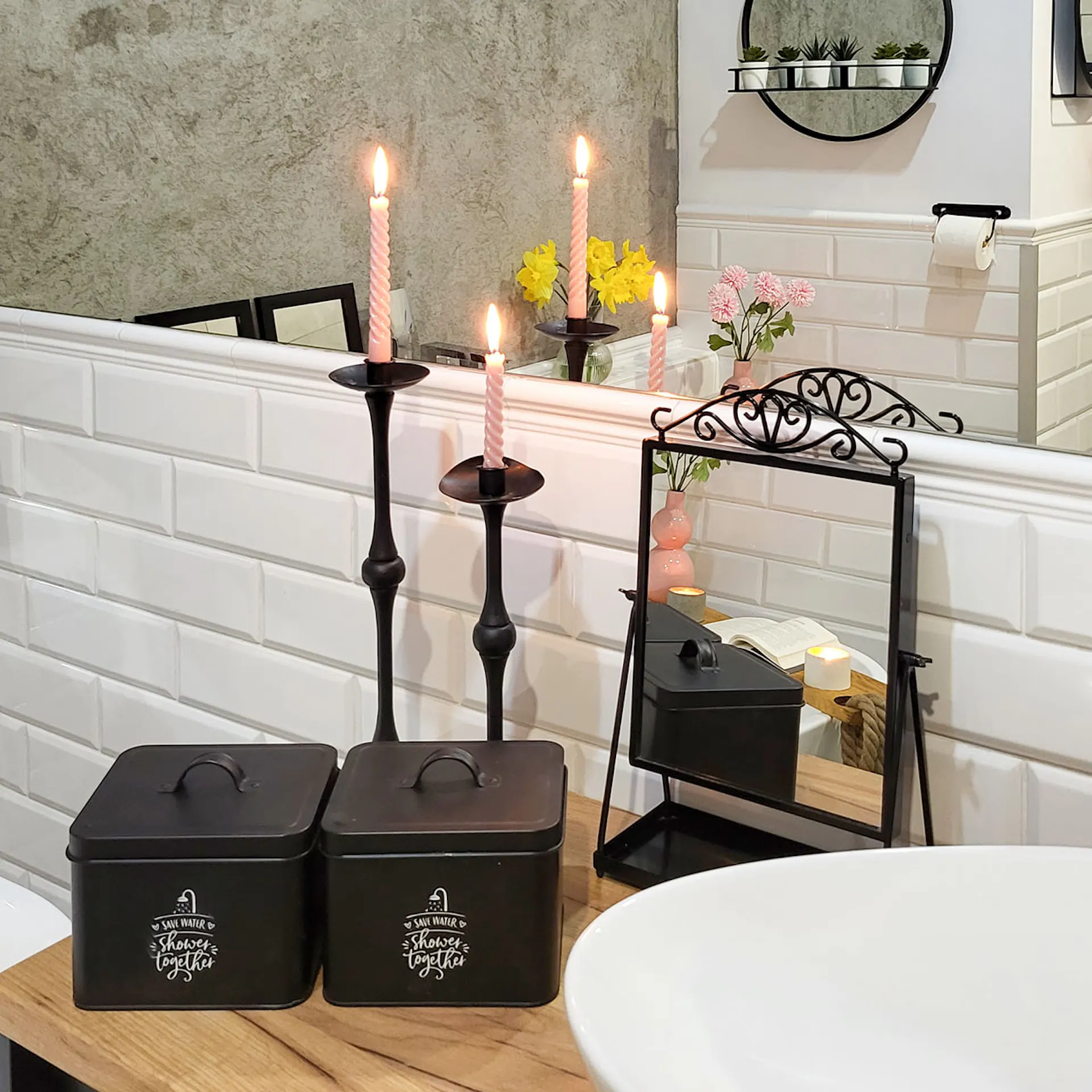 czarne pojemniki, lustro i ozdobne świeczniki na blacie w łazience