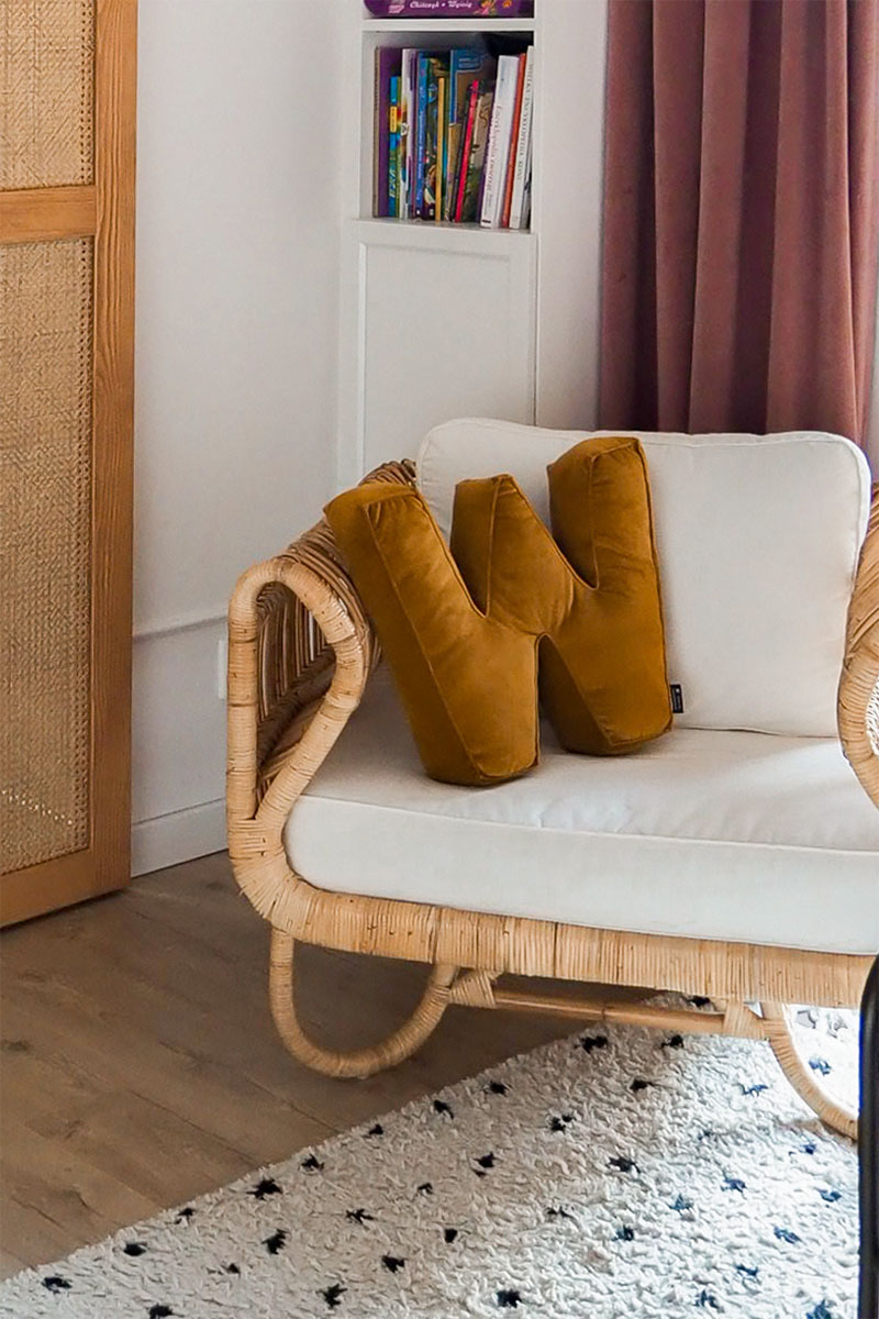 poduszka literka i wiklinowy fotel w pokoju dziewczynki