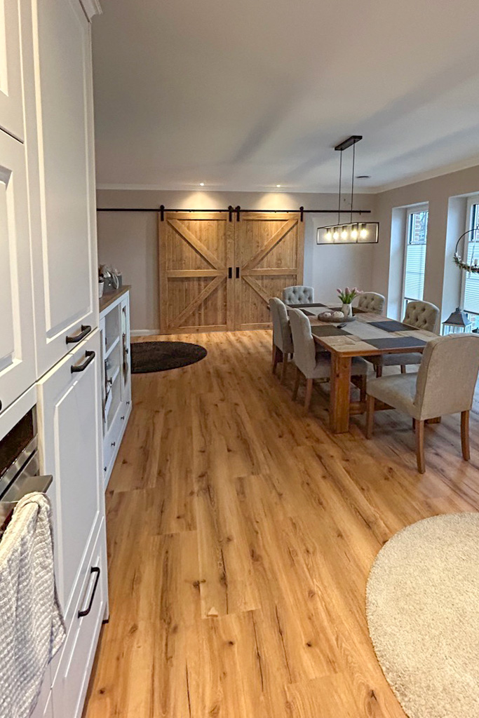 otwarta kuchnia z jadalnią i dwuskrzydłowymi drzwiami przesuwnymi