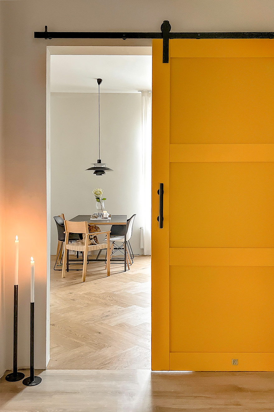 otwarte żółte drzwi ukazujące fragment jadalni