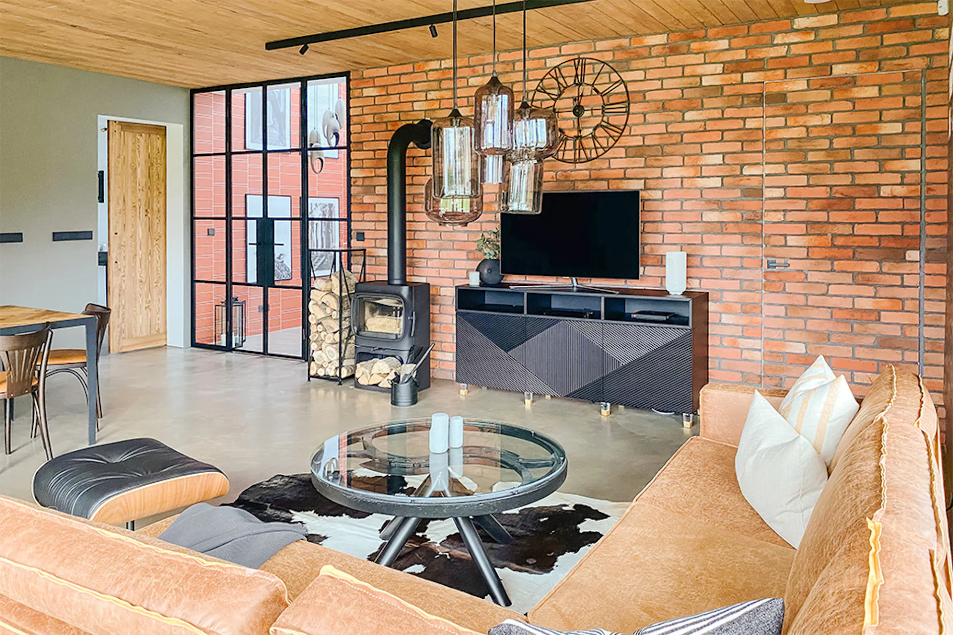 Loftowo-industrialny salon z czarnym kominkiem i cegłą na ścianie