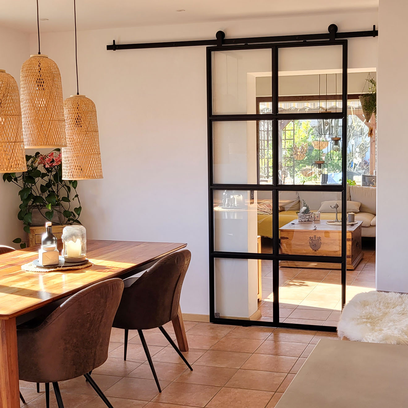 Esszimmer, das durch eine loftartige Schiebetür mit dem Wohnzimmer verbunden ist