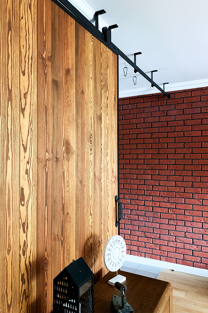 Holzschiebetüren, Schiebetüren in einem Metallrahmen, Ziegel an der Wand